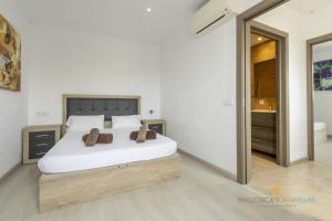a bedroom with a bed with two brown shoes on it at Villa Iola a 150m de la playa ideal para familias y amigos in Playa de Muro