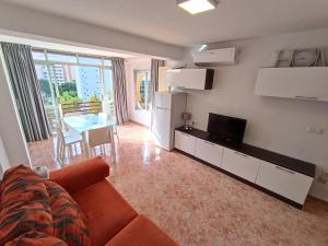 a living room with a couch and a television and a table at MobyDick 5 in Benidorm