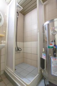a shower with a glass door in a bathroom at Alan rooms for 2-4 people in Taipei