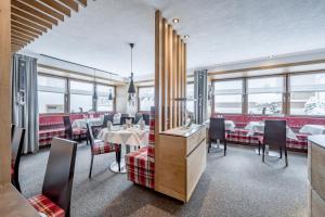 a restaurant with tables and chairs and windows at Hotel Sportpension Carinthia in Sölden