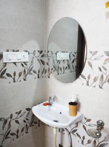 een badkamer met een wastafel en een spiegel bij SHiVAY HOMESTAY in Garudeshwar