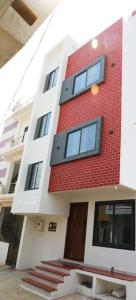 een rood-wit gebouw met een trap ervoor bij SHiVAY HOMESTAY in Garudeshwar