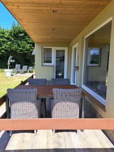 een terras met een houten tafel en stoelen op een huis bij Pavillon du golf in De Haan +44 foto's