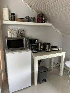 a kitchen with a microwave and a counter with a table at Idyllic upstairs apartment with two bedrooms in Joensuu +13 photos