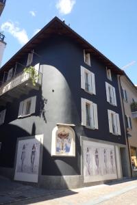 - un bâtiment noir et blanc avec des photos dans l'établissement Appartamenti della Ruga, à Ascona