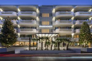 a rendering of a building with palm trees in front at Blazer Suites Hotel in Athens