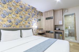 a bedroom with a large bed and a bathroom at Leela Orchid Hotel in Bangkok