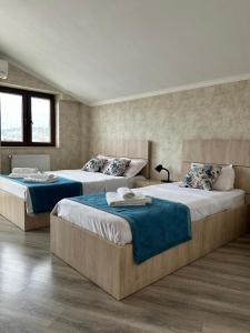 a bedroom with two beds with blue sheets at Tbilisi Center Hotel in Tbilisi City