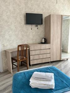 a bedroom with a tv and a bed and a chair at Tbilisi Center Hotel in Tbilisi City
