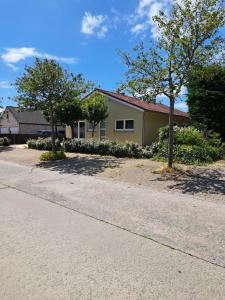 een huis met twee bomen aan de kant van een weg bij Pavillon du golf in De Haan