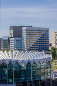 a large building in front of some tall buildings at Beautiful Apartment with Balcony in Heart of Warsaw by Noclegi Renters in Warsaw