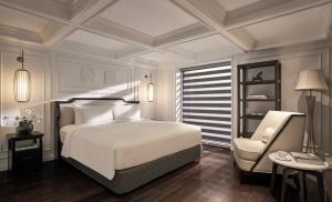 ダラットにあるNIA Hotelの白いベッドと椅子のある寝室 +25枚の写真