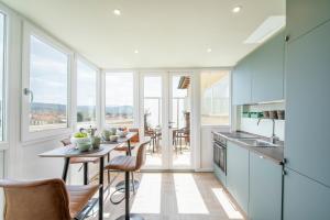 a kitchen with a table and chairs and windows at Penthouse with Terrace over Florence in Florence