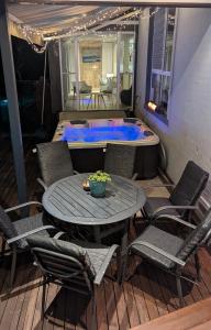 a patio with a table and chairs and a hot tub at Phoenix Oasis, Family and Pet friendly, with private pool and spa in Port Macquarie