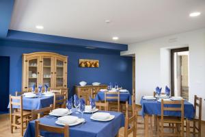 a dining room with blue walls and tables and chairs at Albergue Camino Norte in Castropol