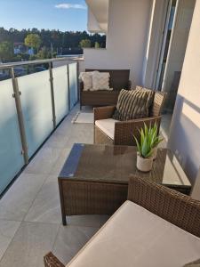 een balkon met een bank, een tafel en stoelen bij Apartament Baltic Sun in Sztutowo