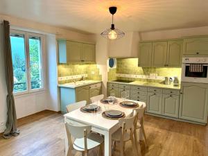 a kitchen with a white table and chairs in it at Duplex familial à la campagne in Orcier