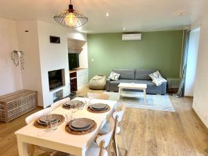 a living room with a table and chairs and a couch at Duplex familial à la campagne in Orcier