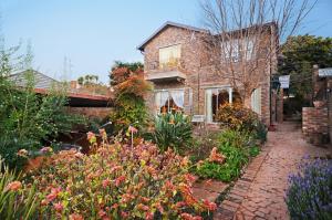 a garden in front of a brick house with flowers at B&B on 8th Avenue in Johannesburg