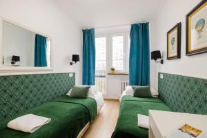 Dos camas en una habitación con cortinas azules. en UNITApartament Short Rent Apartment in Warsaw by Metro Station Rondo ONZ Apart with 3bedrooms 22, en Varsovia