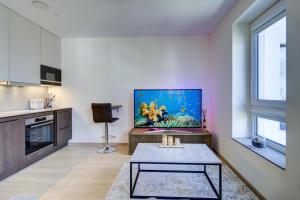a living room with a table and a fish painting on the wall at Kaunas City Center Deluxe in Kaunas