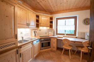 a kitchen with wooden cabinets and a sink and a window at Haus Steinbock Top 1 in Krimml