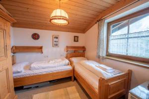 a bedroom with two beds and a window and a chandelier at Haus Steinbock Top 1 in Krimml