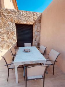 un tavolo bianco e sedie su un patio di Villa Casa Maredda bord de mer avec piscine a Palasca