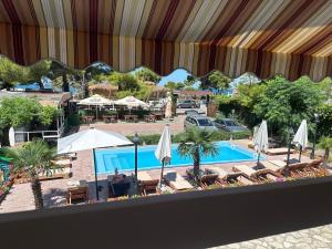 a view of a swimming pool with umbrellas and chairs at Bujtina e Zefit in Shëngjin