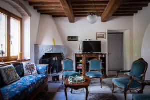 een woonkamer met een bank, stoelen en een tv bij Agriturismo Le Pozze in Poppi