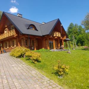 a large wooden house with a gambrel roof at Góralski Domek Na Skarpie in Piwniczna Zdrój