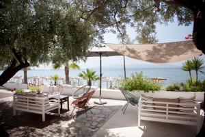 a patio with chairs and a table and an umbrella at Akti Hotel Kavala in Paleo Tsifliki