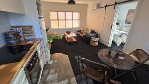 a kitchen and living room with a table and a couch at Apartment 2 - Haddin Court - Stunning Executive in Blenheim +6 photos