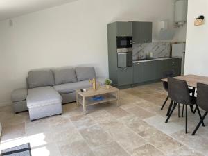 Una sala de estar con un sofá y una mesa y una cocina. en Domaine de l'Aumone, en Agde