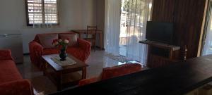 a living room with red chairs and a tv at Maison Angèle in Nosy Be