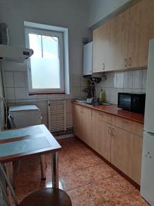 a kitchen with wooden cabinets and a table and a window at APARTMENT POPS in Cluj-Napoca