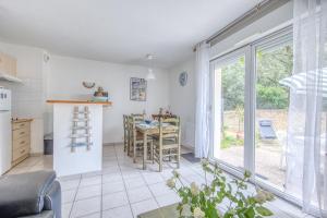 kuchnia i jadalnia ze stołem i oknem w obiekcie Maison de ville Domaine des sables w mieście Soulac-sur-Mer