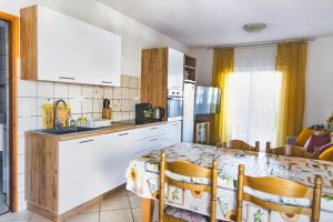 a kitchen with a table with chairs and a counter top at Apartment Anamaria in Pag