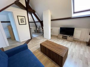 a living room with a blue couch and a tv at Appartement entier Centre ville in Melun