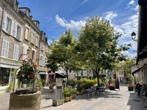 a city street with tables and chairs and trees at Appartement entier Centre ville in Melun