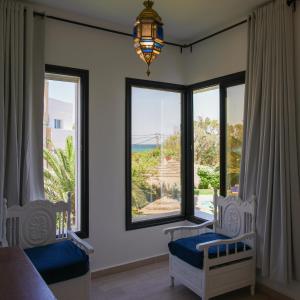 a bedroom with two beds and a large window at Dar Oguz in Ḩammām al Ghazzāz +72 photos