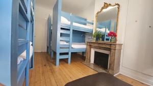 a room with a bunk bed with a mirror and a fireplace at Bed in 6-Bed Mixed Dormitory Le Jardin Cafe in Bordeaux