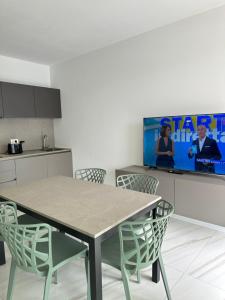 a kitchen with a table and chairs and a tv at Beach Palace with small swimming pool, private beach, parking in Lido di Jesolo