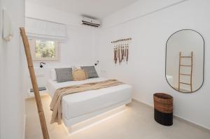 a white bedroom with a bed and a mirror at Country Villas in Stelida +128 photos