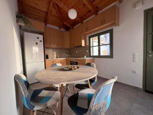 a kitchen with a table and chairs and a refrigerator at Xasteria apartment Ξαστεριά in Poros