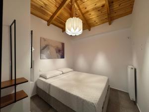 a bedroom with a bed and a chandelier at Xasteria apartment Ξαστεριά in Poros