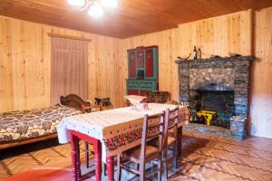 a dining room with a table and a fireplace at Guesthouse Svani in Ushguli