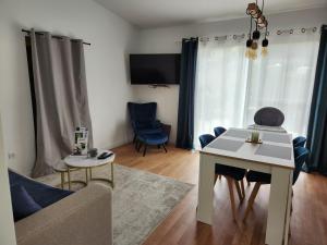 Una sala de estar con una mesa blanca y un sofá. en La petite maison d'Adèle, en Hargeville-sur-Chée