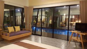 a living room with a couch and a swimming pool at Jasmine Resort And Spa in Khanom