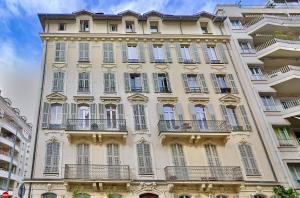 a tall building with balconies on the side of it at Family Room in Nice
